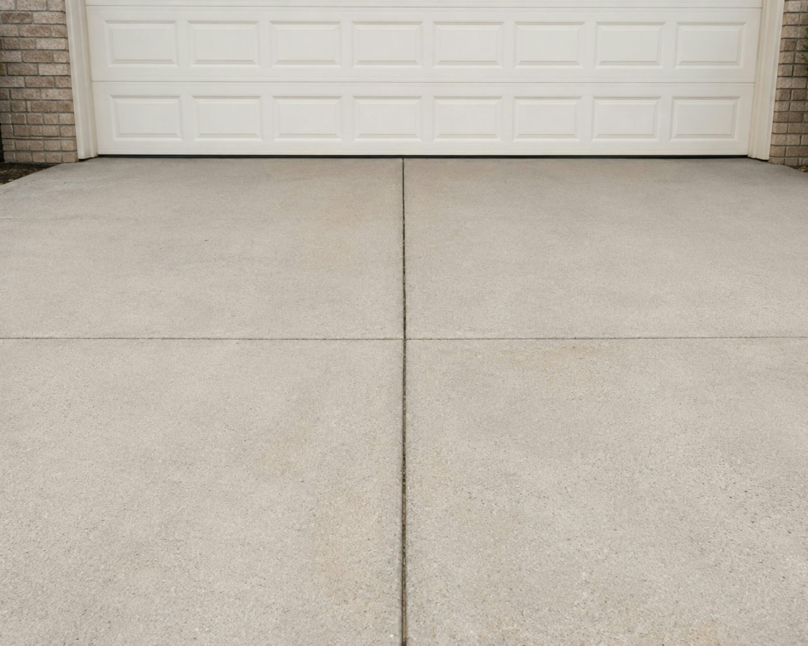 Concrete driveway in front of a white garage