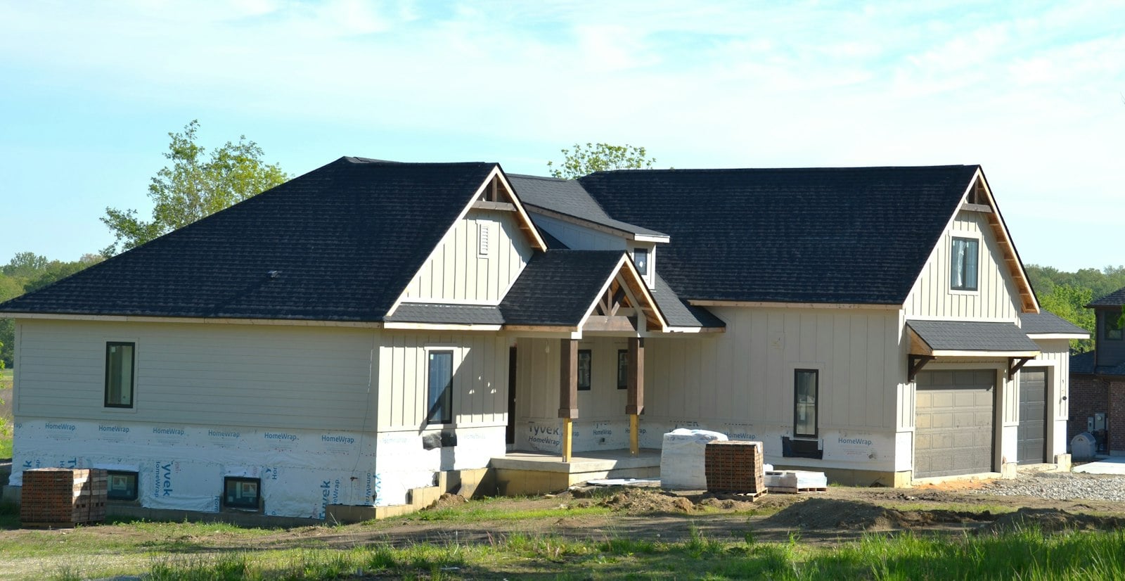 New house under construction with a dark roof