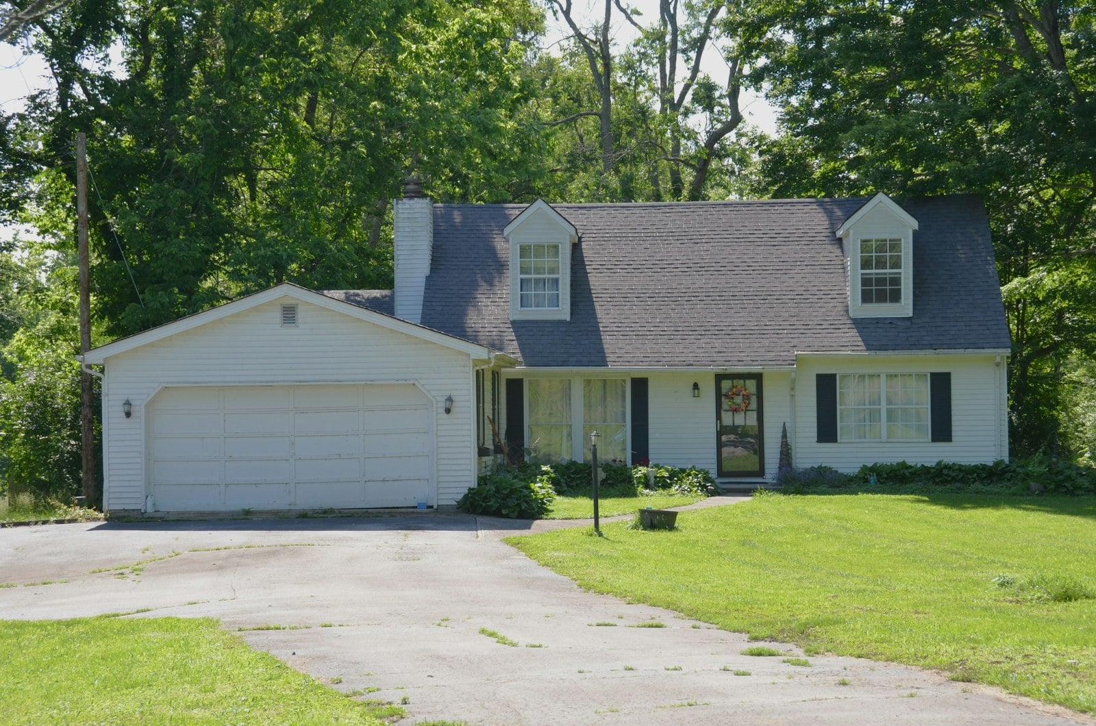 White house with a driveway and a green lawn